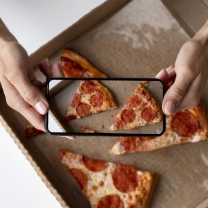 Taking a photo of pepperoni slices to share on social media.
