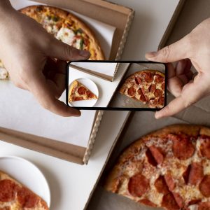 Taking a photo of pepperoni pizza to share on social media.